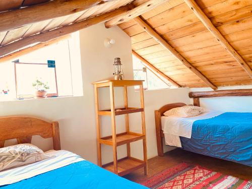 奥兰太坦波Cabaña del viajero.的配有木天花板的客房设有两张床。