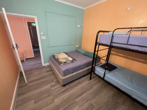 达尔文The Cozy Hostel - Motel的带两张双层床的客房和走廊