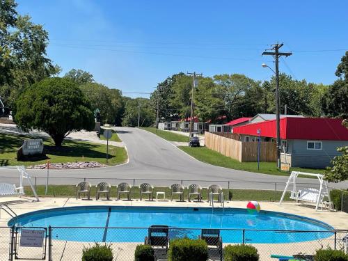 布兰森Hunter's Friend Resort Near Table Rock Lake的路边带椅子的游泳池