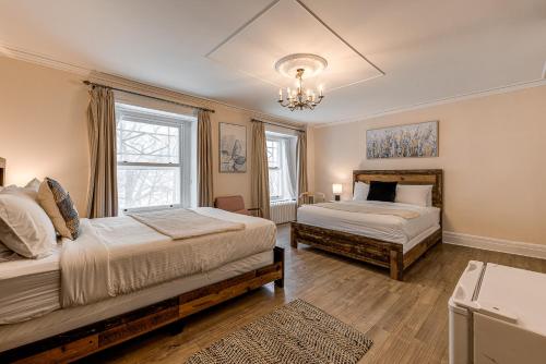 魁北克市拉舒尔特旅舍的一间卧室配有两张床和吊灯。