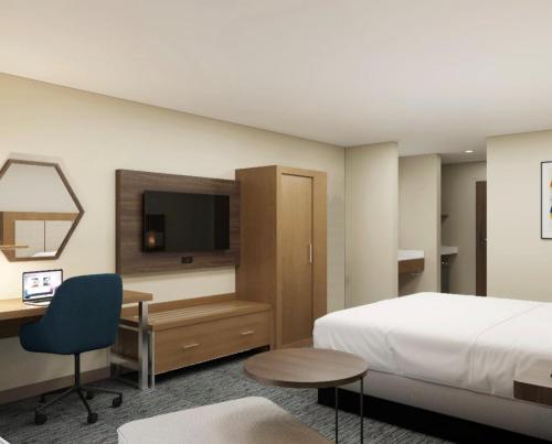 雷丁雷丁华美达有限酒店的酒店客房配有一张床、一张书桌和一台电视。