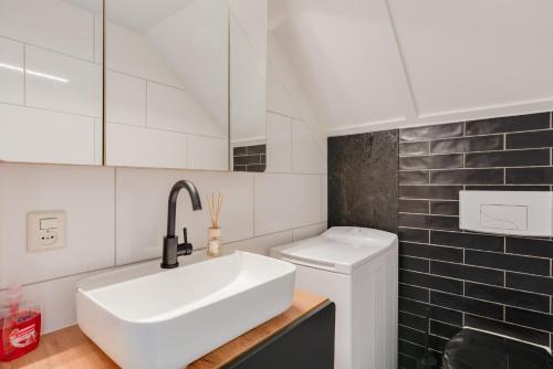 EwijkHet Huys Ewijk mooi luxe en een laadpaal的白色的浴室设有水槽和卫生间。