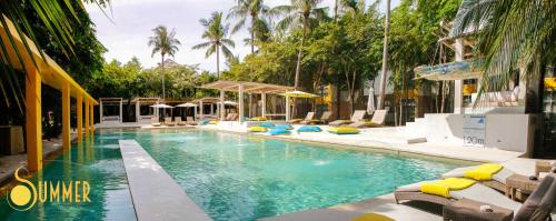 班泰Summer Luxury Beach Resort & Spa的一个带躺椅的游泳池,棕榈树
