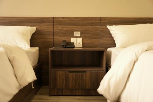 广义Tuyet Suong Hotel的酒店客房设有两张床和一部位于床头柜上的电话