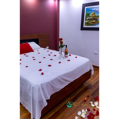 卡哈马卡Hotel Valle Verde的一间卧室,配有一张玫瑰花桌