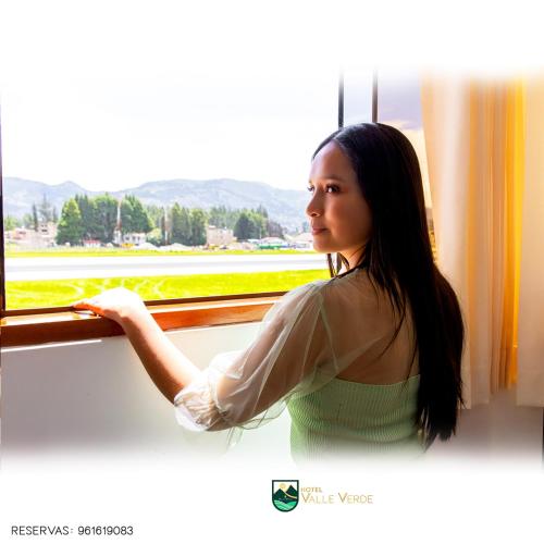 卡哈马卡Hotel Valle Verde的女人从窗口看出来