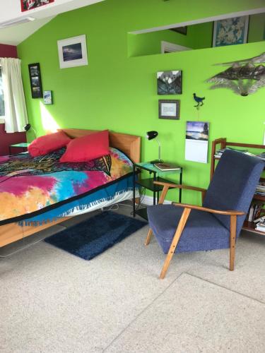 但尼丁Piringa的一间卧室设有一张床和绿色的墙壁