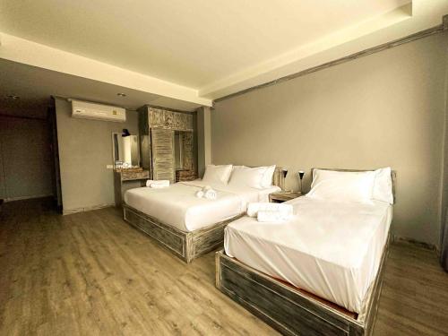 苏梅岛JALMIN Hotel Samui的配有白色床单的酒店客房内的两张床