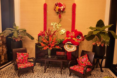 顺化Thuy Duong Boutique Hotel Hue的一间设有椅子、面具和鲜花的房间