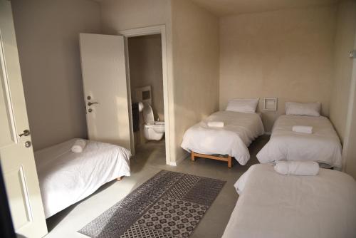 Shadmot Devoraחאן דרך העץ - חדרי מטיילים的小房间设有三张床和卫生间