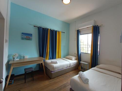 仙本那DONG’HOME东东小院的客房设有两张床、一张桌子和一个窗户。