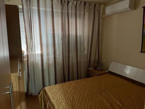 萨图马雷Apartament cu un dormitor / One bedroom apartment的一间卧室配有床和带窗帘的窗户