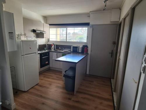 佩萨克APPARTEMENT EN PLEIN CENTRE VILLE PESSAC AVEC 3 CHAMBRES的一间带桌子和冰箱的小厨房