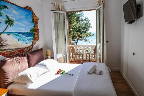 都拉斯COSMO Beach Hotel的一间卧室设有一张床和一个大窗户