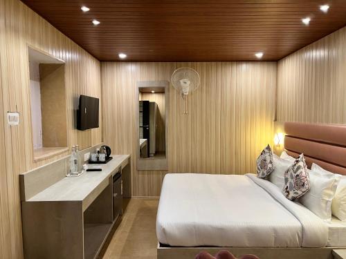 穆索里Wabi Sabi Stays - Pride Inn的一间卧室配有一张床、一张桌子和一个水槽