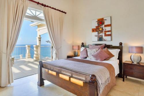 Cap EstateGrandiose 4 BR Sea Facing Villa的一间卧室设有一张床和一个海景阳台