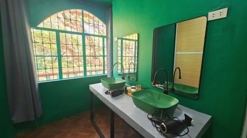 科隆80 Bar Hostel的绿色浴室设有水槽和镜子