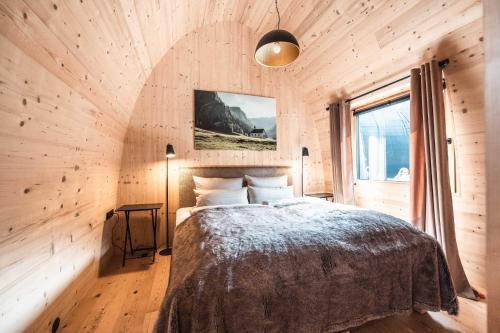 嫩青Himmelchalet - Alpencamping Nenzing的卧室配有木墙内的一张床