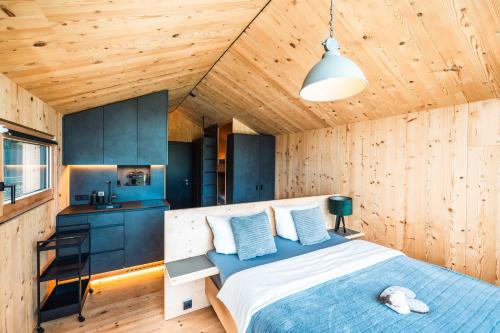 嫩青Himmelchalet - Alpencamping Nenzing的木制客房内的一间卧室,配有一张床
