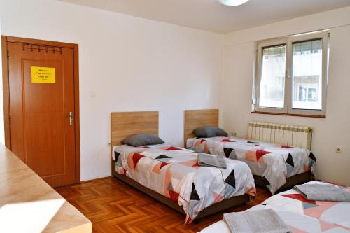 斯科普里Guest House Sani的一间设有两张床和一扇门的房间