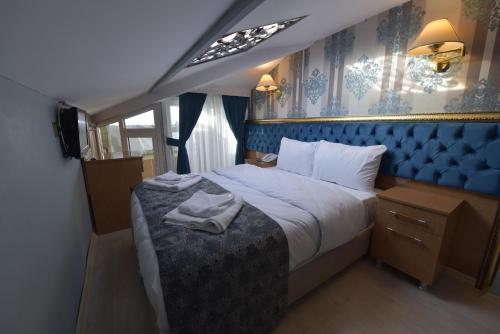 伊斯坦布尔GOLDEN PALACE SEA ViEW的一间卧室配有一张蓝色床头板的大床