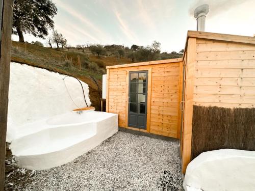 AlmogíaRomantic accommodation - Hottub & Sauna的木结构建筑旁的浴缸