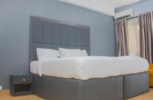 拉各斯MORADA HOTELS LTD的一间卧室配有一张大床和大床头板