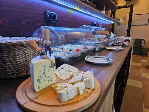 普特纳Pensiunea Mușatinii的自助餐厅在柜台上供应奶酪和其他食品