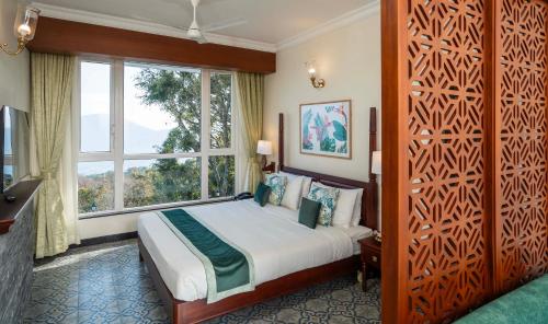 钦纳卡纳Fort Munnar的一间卧室设有一张床和一个大窗户