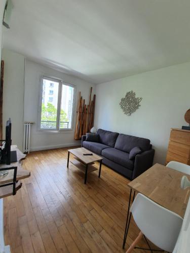 巴黎Chambre privée dans magnifique appartement calme的客厅配有沙发和桌子
