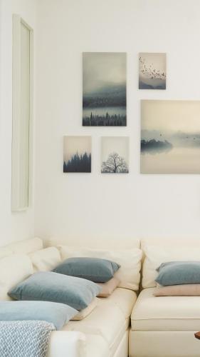 阿布扎比Canal view 3 bedroom holiday home with balcony的客厅里的白色沙发,墙上挂着照片