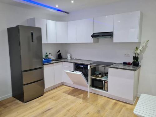 安特卫普ANTWERP Charming Studio的厨房配有白色橱柜和不锈钢冰箱