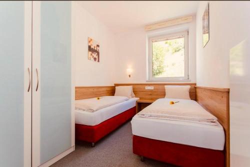 卡普伦Gletscherblick Resort Kaprun by Jara的小型客房 - 带2张床和窗户