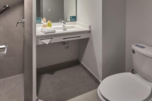华雷斯城City Express Junior by Marriott Juarez Consulado的浴室配有白色卫生间和盥洗盆。