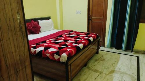 加济阿巴德Madhav palace的一间卧室配有一张带红白色棉被的床