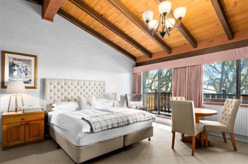 布勒山格里莫斯酒店的卧室配有一张床和一张桌子及椅子