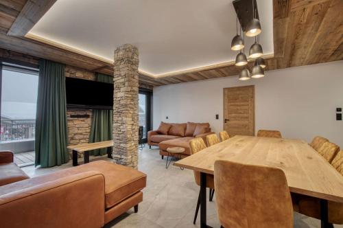 蒙特瓦勒赞Lodge des Glaciers的客厅配有桌子和沙发