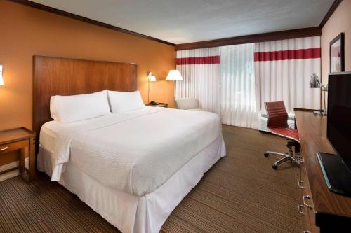 堪萨斯城堪萨斯城机场福朋喜来登酒店的酒店客房设有一张大床和一台电视。