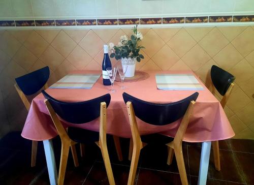 巴尔韦尔德Mi Parchita的粉红色的桌子、椅子和一瓶葡萄酒