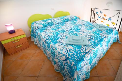 切塔拉Casa vacanze "Il Baffo e il Mare"的一间卧室配有一张带蓝色棉被的床