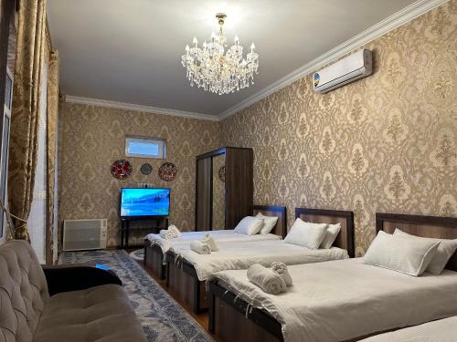 撒马尔罕Guest house Chehra的一间卧室配有三张床和吊灯。