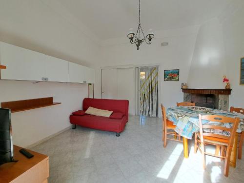 托雷圣乔万尼乌Appartamento La Torre的客厅配有红色椅子和桌子
