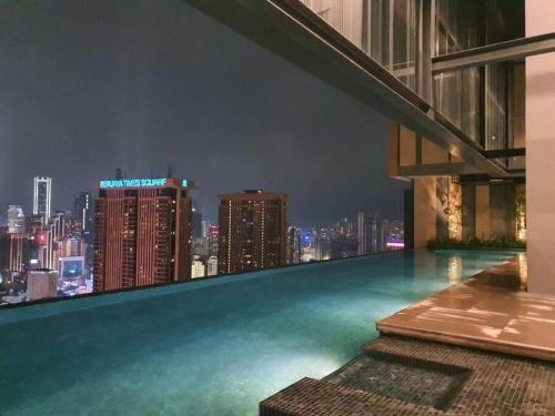 吉隆坡Lucentia Residence by EAS Maju property的屋顶游泳池,晚上享有城市天际线
