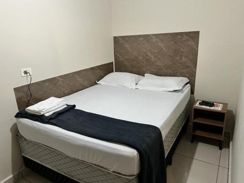 瓜鲁柳斯Hostel Quartos com banheiro individual perto do Aeroporto的卧室配有一张带白色床单和枕头的大床。