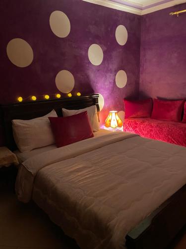 拉巴特Dar El Yacout的一间卧室设有一张大床和紫色的墙壁