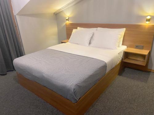 厄森尤特Rosse Hotel的一张带白色床单和枕头的床
