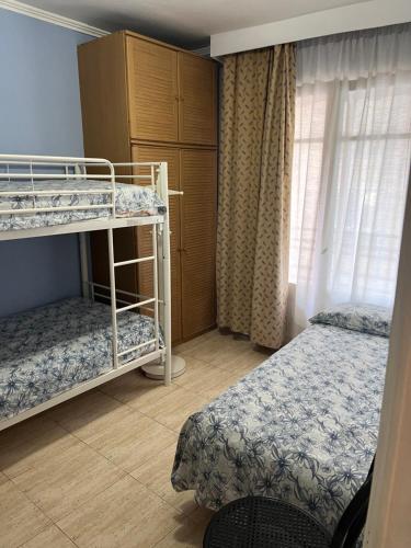塔拉戈纳阿尔克劳赛尔公寓的一间卧室设有两张双层床和一扇窗户。