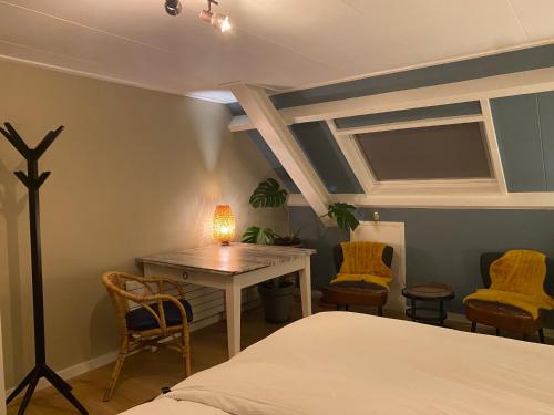 阿纳姆Bed and breakfast Carma Arnhem的卧室配有一张床和一张桌子及椅子