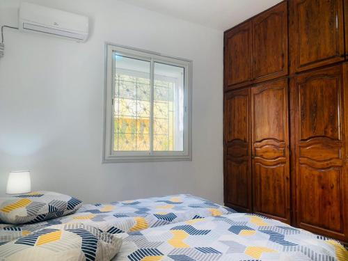 GabèsDar chenini的一间卧室配有一张床、一个梳妆台和一扇窗户。