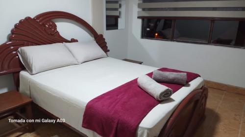 苏克雷Posada de Mary的卧室配有白色床和紫色毯子